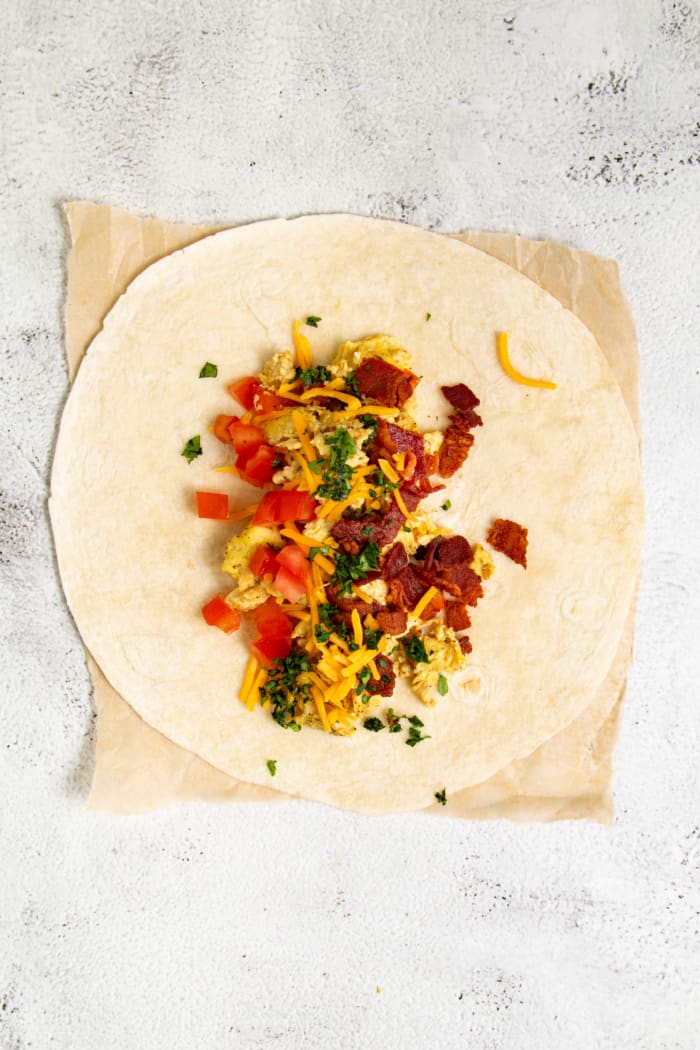 Wrap with eggs, bacon, cheese, and peppers.