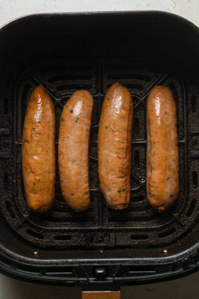 Sausage in air fryer basket.