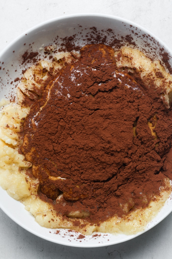 Cocoa powder and banana in bowl.
