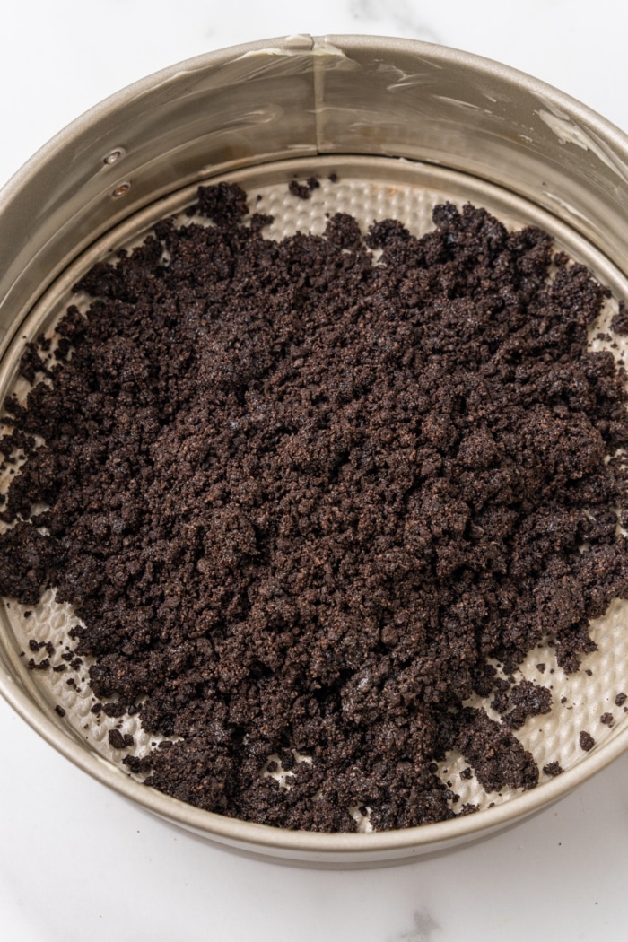 Oreo crumbs in springform pan.