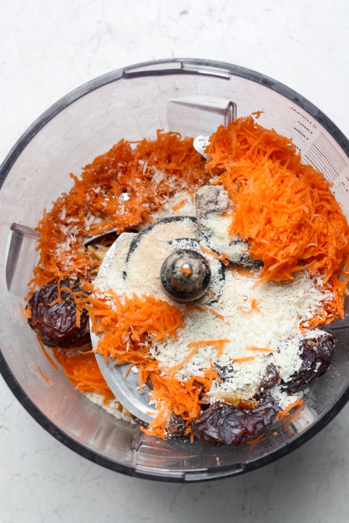 Shredded carrots and coconut in food processor.