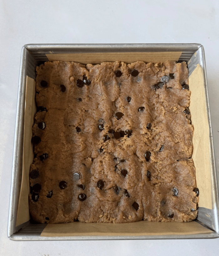 Square pan with cookie dough.