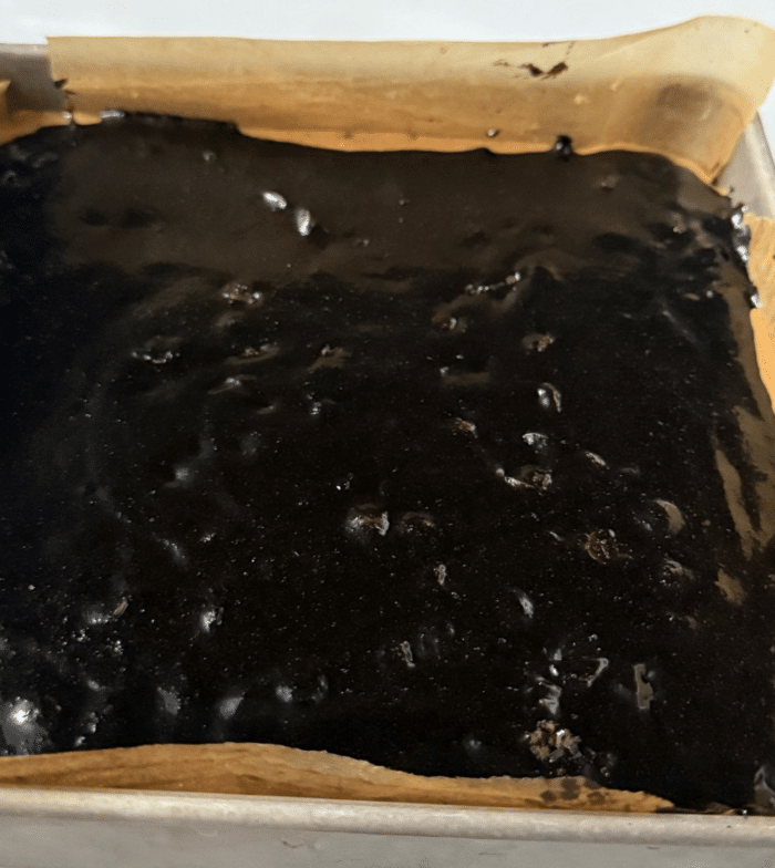 Chocolate batter in square pan.