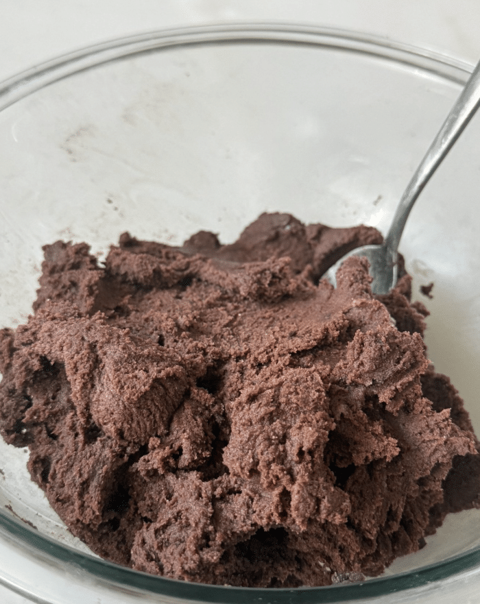 Thick chocolate batter in glass bowl.