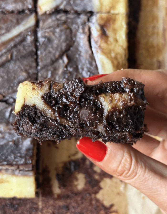 Hand with cheesecake brownie.