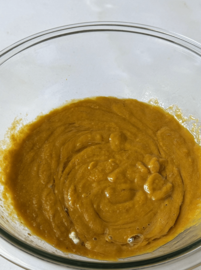 Glass bowl with orange dough.